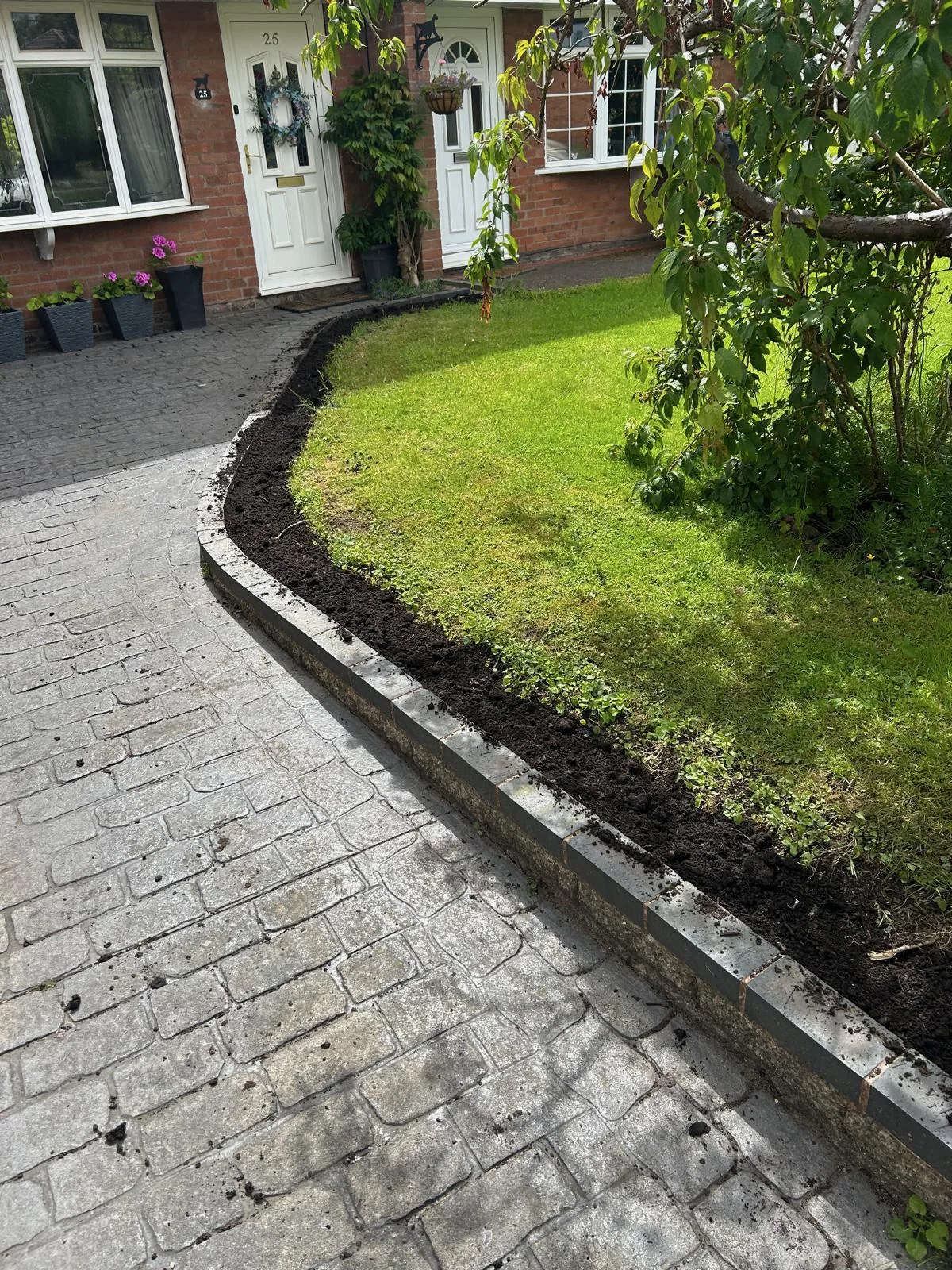 Driveway and path edge after moss removal and jet washing in Staffordshire.